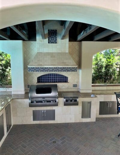 An outdoor kitchen with a grill and oven.